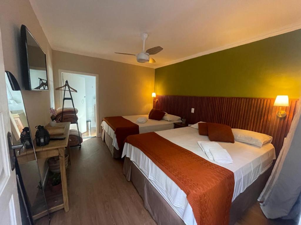 Quarto com duas camas e mesa de apoio na Pousada dos Franceses